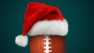 Illustration of a football wearing a red furry Santa hat in front of a teal background